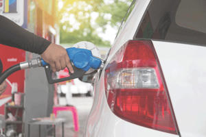 white van getting gas with a blue pump