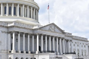 Capital Building in Mid daylight, with flag waving on top of it